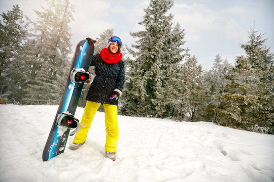 Sport girl with snowboard outdoors -winter resort