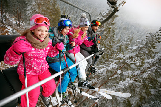 Skiing, ski lift, ski resort - happy family skiers on ski lift