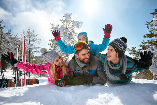  young family having fun on fresh snow on winter vacation