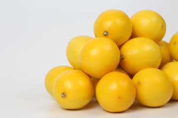 pyramid of whole lemons on a white background.