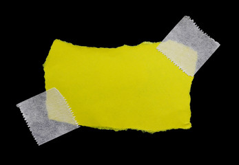 ripped note paper with adhesive tape on a black background