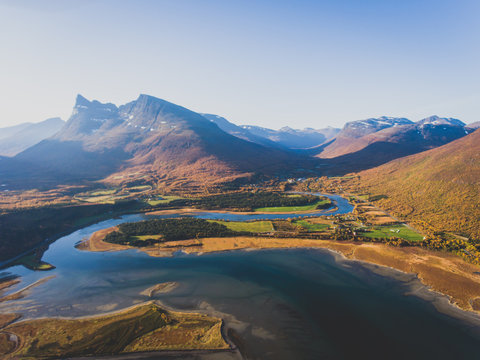 Classic norwegian scandinavian summer mountain landscape view with road, mountains and fjord with a blue sky, northern Norway, Finnmark County, shot from drone