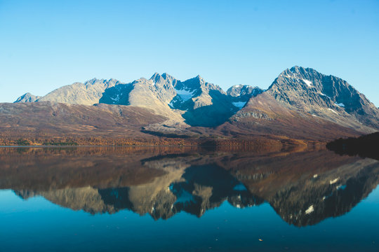 Beautiful vibrant summer view of Norwegian mountains and fjord reflection, Lyngen Alps, Finnmark county, northern Norway