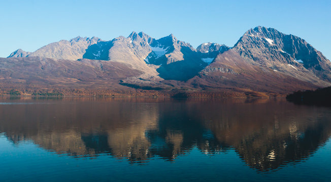 Beautiful vibrant summer view of Norwegian mountains and fjord reflection, Lyngen Alps, Finnmark county, northern Norway