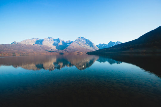Beautiful vibrant summer view of Norwegian mountains and fjord reflection, Lyngen Alps, Finnmark county, northern Norway