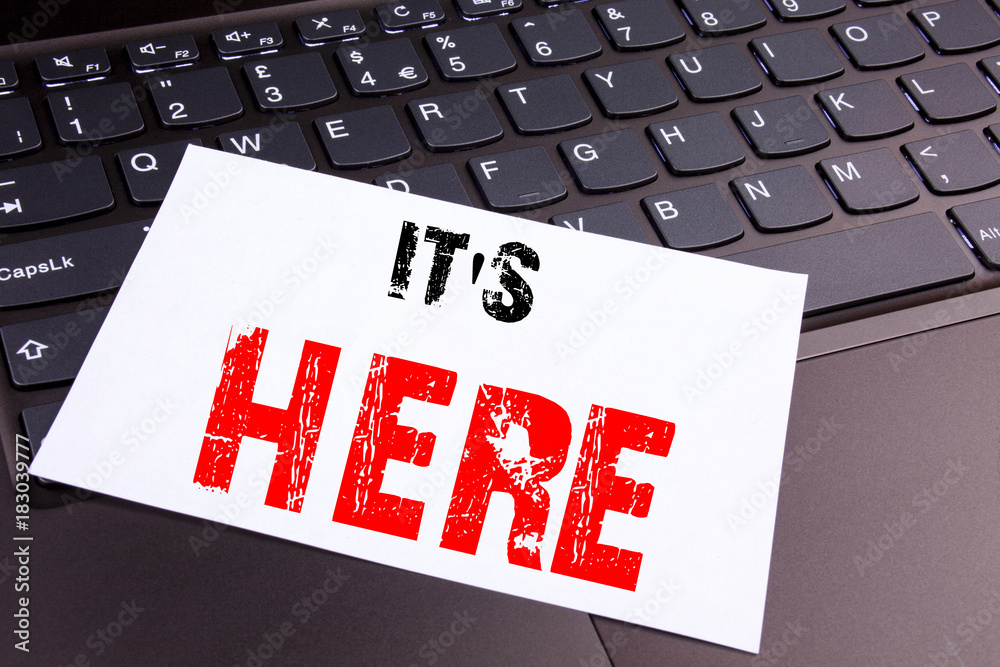 Poster writing it's here text made in the office close-up on laptop computer keyboard. business concept for