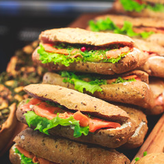 Beautifully decorated catering banquet table with different food snacks and appetizers with sandwich, on corporate christmas birthday kids party event or wedding celebration