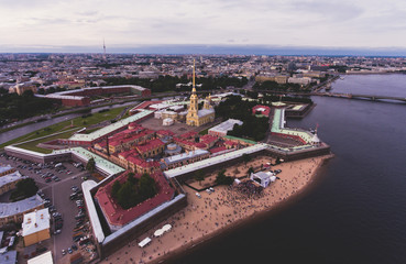 Fototapeta premium Beautiful aerial morning view of Saint-Petersburg, Russia, The Vasilievskiy Island at sunrise, Isaacs Cathedral, Admiralty, Palace Bridge, cityscape and scenery beyond the city, shot from drone