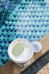 Chlorine in white plastic container on swimming pool edge, swimming pool treatment, disinfection power