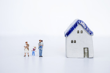 Fototapeta na wymiar Family concept, miniature family with ceramic vintage miniature house on white background