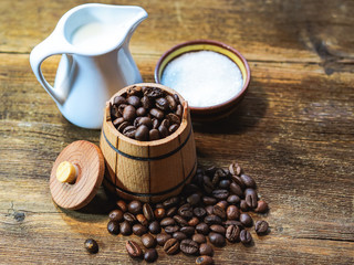 Coffee beans in a decorative barrel on a wooden table