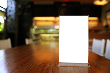 Mock up Menu frame standing on wood table in Bar restaurant cafe. space for text.