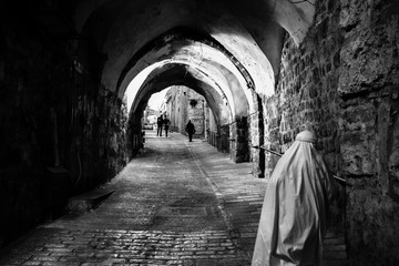 BAITULMUQADDIS, PALESTINE - 11TH NOV 2017; Pilgrimage walking down the alley in Jerusalem old city,...