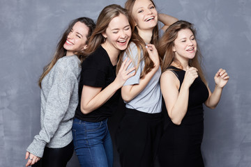 Portrait of four females having hen party laughing loudly, having fun together. Best friends meeting, celebrating event or having rest during weekends. Only girls spending good time with each other.