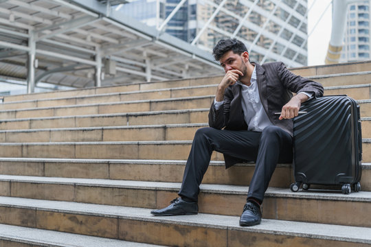 Unemployed businessman stress sitting on stair, concept of business failure and unemployment problem, work life balance.