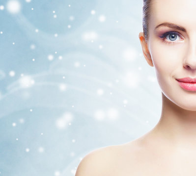 Portrait of young, beautiful and healthy woman: over winter background. Healthcare, spa, makeup and face lifting concept.