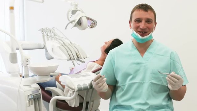 Portrait of adult dentist in medical center standing near the chair
