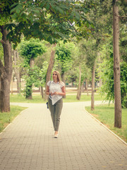 Beautiful woman in a business suit in the alley of the city Park.