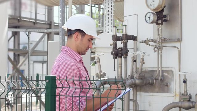 Engineer check parameters on instrumentation at chemical factory