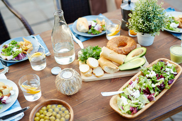 Vegetarian food, homemade drinks and fresh bread on served table prepared for guests outdoors