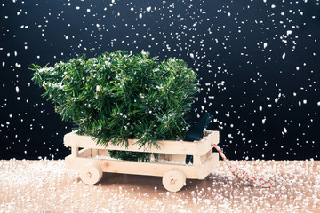 christmas tree on wooden trailer  with many sprinkle fake snow