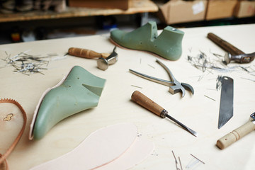 Shoe workpieces and handtools of cobbler on table of shoemaker