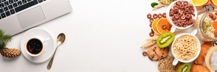 Business breakfast, muesli, coffee, milk, fruits, nuts and seeds, on a wooden surface. Top view. Free space for text.