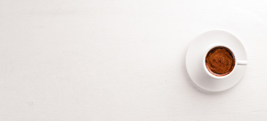 Espresso coffee cup on a white wooden background. Top view. Free space for text.