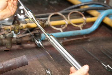 Factory of Christmas toys. The worker blows out the glass. The b