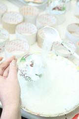 Factory of Christmas toys. The worker blows out the glass. The burner melts the glass. Decoration of a Christmas tree toy. Handmade. Manufacture of fur-tree toys. Many beautiful glass beads.