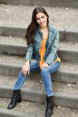 Woman with nice hair wearing casual clothes in urban steps.