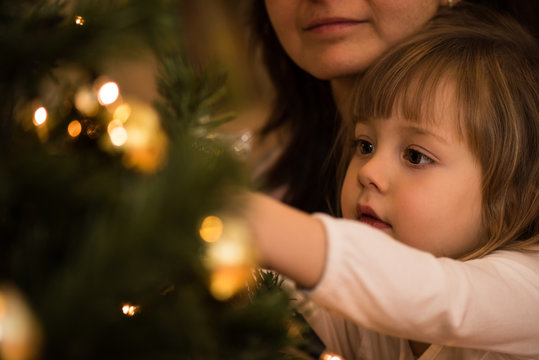 Little girl busy in decorating christmas tree
