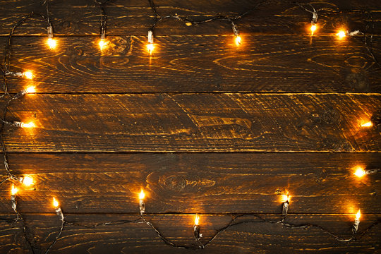 Christmas lights bulb on wood table. Merry christmas (xmas) background. topview, border design - rustic and vintage styles