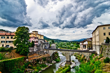 stone bridge connects two sides of an ancient village under cloudy sky