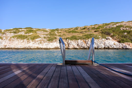 The rear deck of a sailing yacht, over the gorgeous waters of Arki island, Dodecanese, Greece