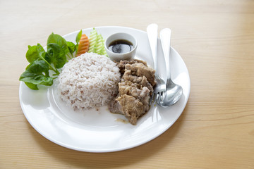 Steamed rice with stew pork in sauce and fresh vegetable side dish. this  is thai food.