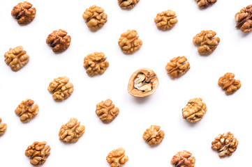 Walnut kernel pattern backdrop. One open nut shell with kernel on white background. Top view.