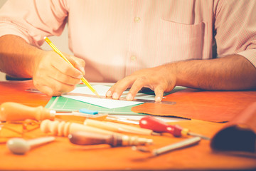 Naklejka premium Leather craft man is cutting leather pattern