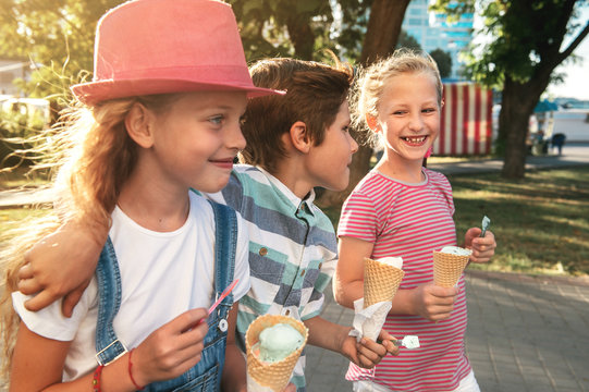 Close-up portrait of three happy preteen children walking on the street, having fun and eating ice-cream - Powered by Adobe