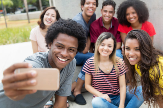 Large Group Of International Young Adults Taking Selfie With Phone