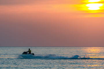 Silhouette of man on the jetski at sunset