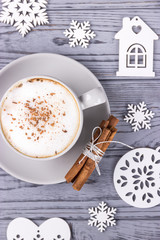 Christmas composition on a gray background. Cappuccino with cinnamon and Christmas tree decorations.Top view
