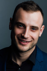 Close-up portrait of a attractive handsome man. Good nice guy looks at the frame.