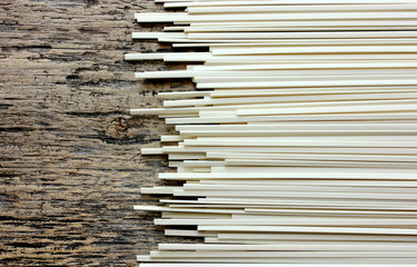 Udon noodles uncooked on a wooden background close up
