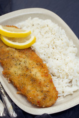 fried fish with lemon and boiled rice on dish