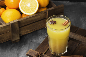 Winter hot drink from oranges and spices on a black background. Copy space. Food background