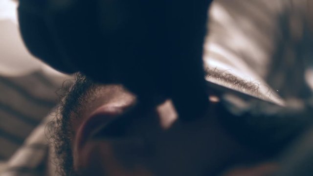 The barber shaves his head, mustache and beard to the man in the barbershop. The stylist uses a classic sharp razor, neatly shaving the client.