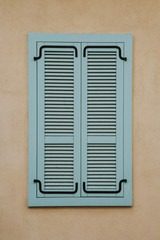 Wooden window shutters isolated on yellow wall urban background.