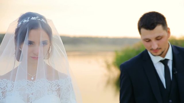 bride and groom embrace on a wedding walk against the lake