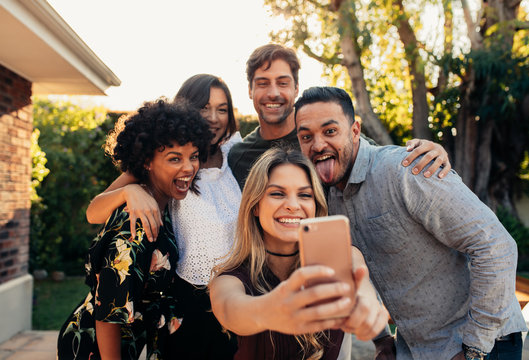 Young friends at housewarming party taking selfie